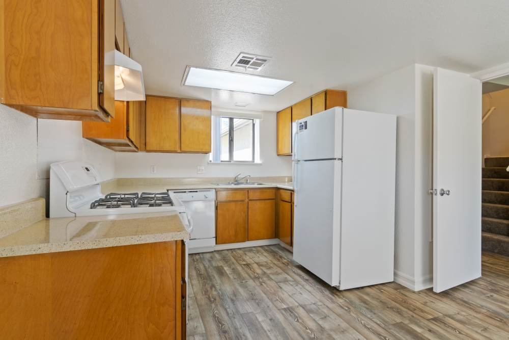 A kitchen with wood flooring at Miramar Townhomes in San Diego, California
