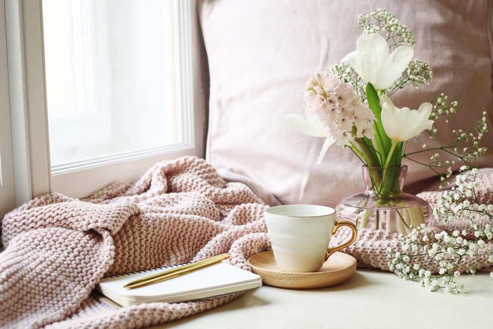 Blanket and warm mug in a cozy corner of an apartment at Spring Hollow Apartments in Brighton, Colorado