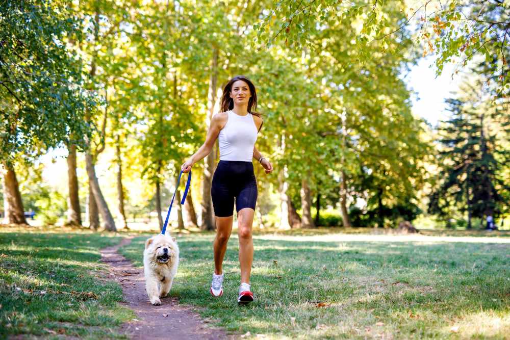 Resident walking her dog at The Abbey at Medical Center in San Antonio, Texas
