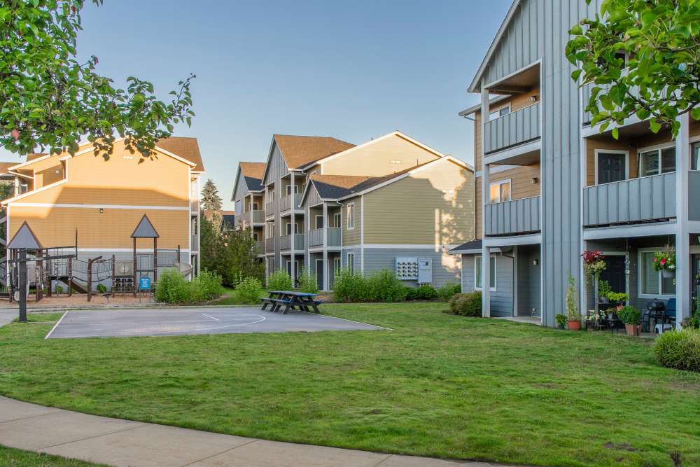 Picnic tables and basketball court by playground at Rock Creek Commons in Vancouver, Washington