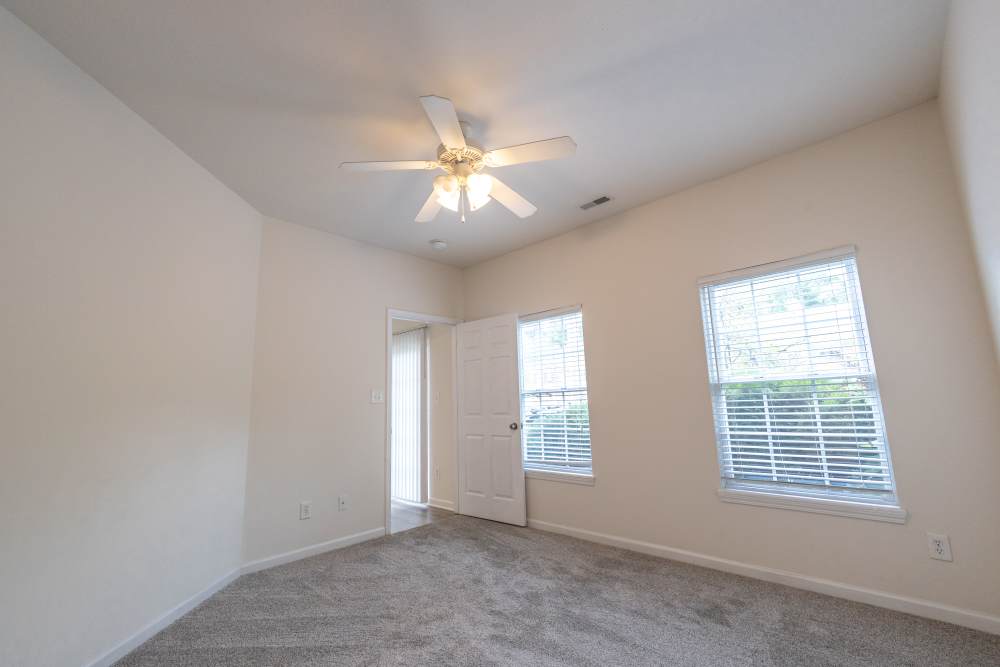 Spacious bedroom with ceiling fan and large windows at Forest Ridge in Bloomington, Indiana, 