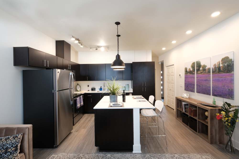 Fully-equipped kitchen with stainless steel appliances and island with bar stools and pendant lights at 27 Elm in Redmond, Oregon, 