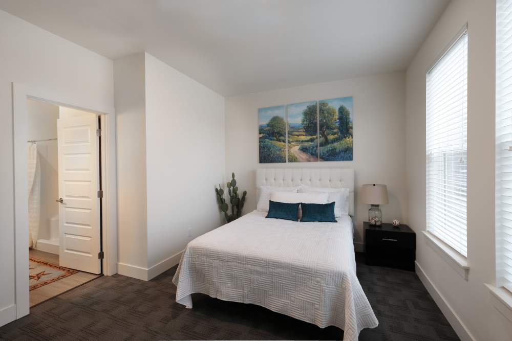 Bedroom with plush carpeting and large window at 27 Elm in Redmond, Oregon, 