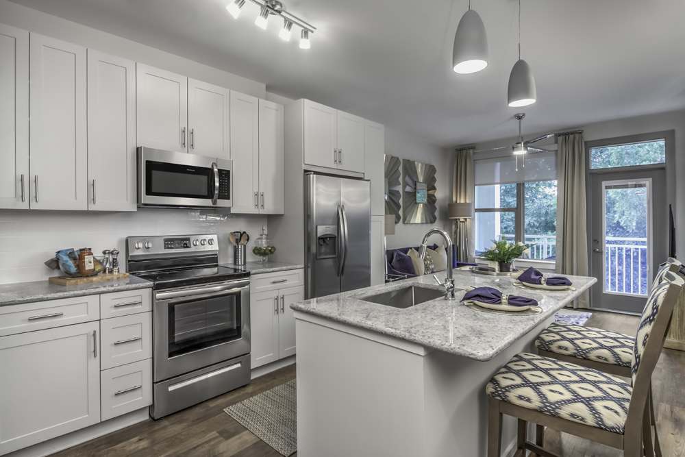 Modern kitchen with stainless-steel appliances, granite countertops and wooden cabinets at Greenside in Charlotte, North Carolina