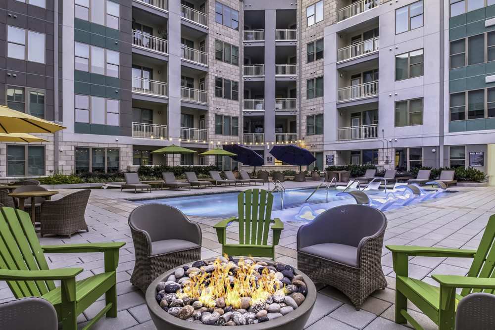 Resort-style swimming pool with outdoor dining and firepit at Greenside in Charlotte, North Carolina