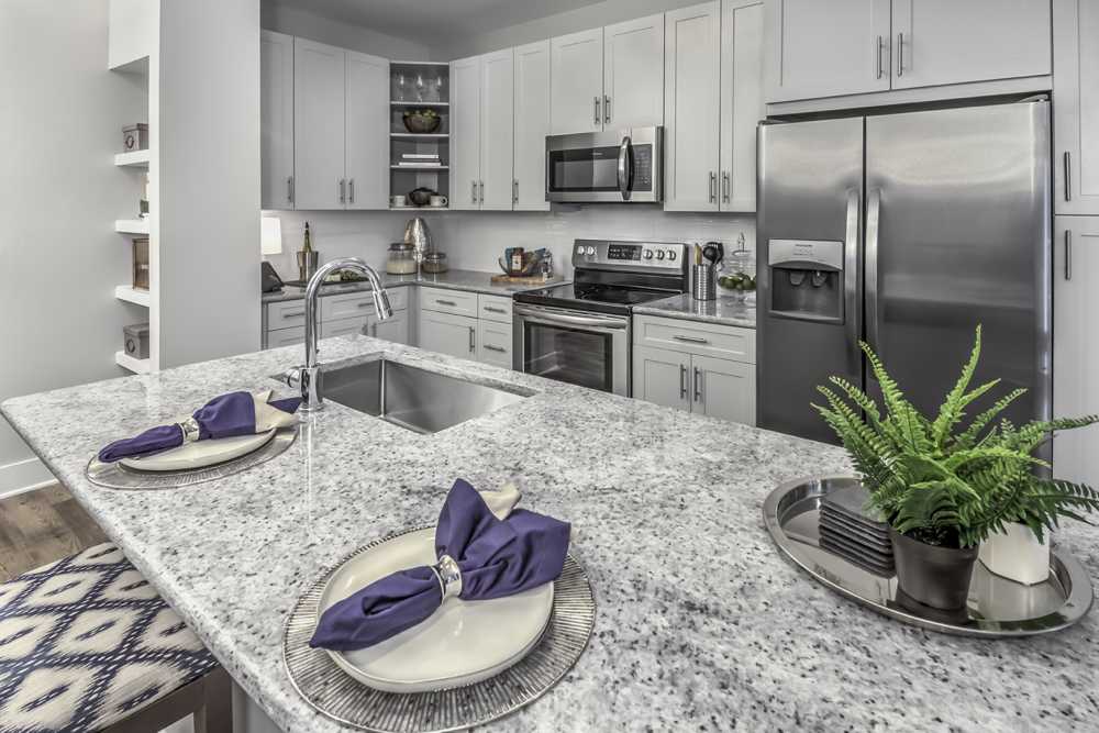 Breakfast counter and a kitchen with wooden cabinets at Greenside in Charlotte, North Carolina