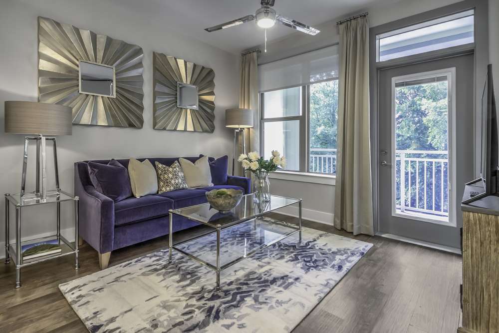 Spacious living room with a couch and a large window at Greenside in Charlotte, North Carolina