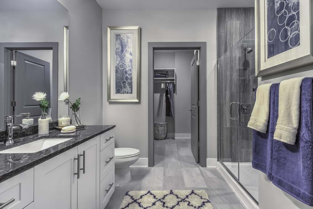 Bright bathroom with a toilet, large mirror and storage units at Greenside in Charlotte, North Carolina