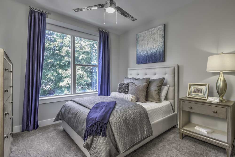Spacious bedroom with a comfortable bed, large window and a ceiling fan at Greenside in Charlotte, North Carolina