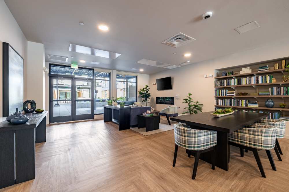 Community clubhouse with seating, fireplace, and TV at Traditions at Hazelwood in Portland, Oregon