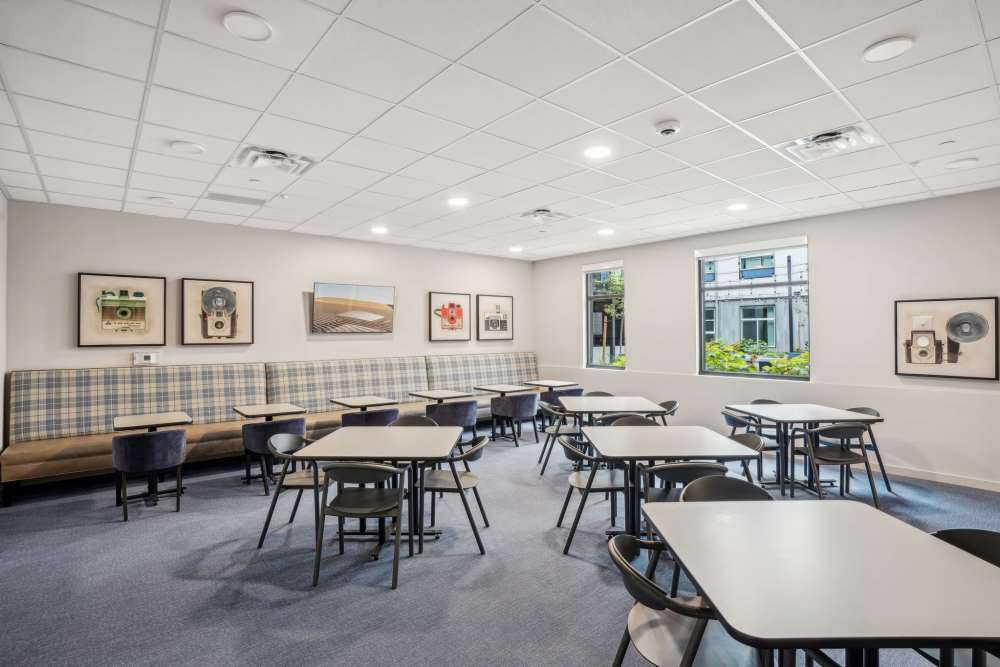 Community multipurpose room with seating, tables, and TV at Traditions at Hazelwood in Portland, Oregon