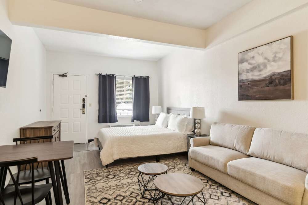 Studio apartment with couch, bed and dining chair at Vivo Living Kissimmee in Kissimmee, Florida