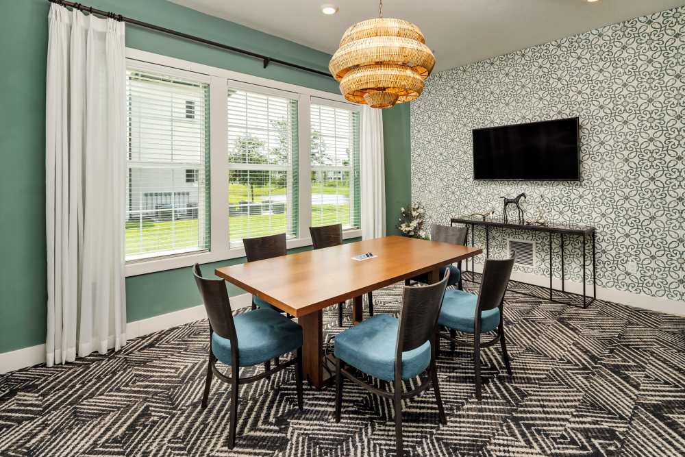 A large dining table next to the kitchen in the community clubhouse at Shadetree Apartments in Ruskin, Florida