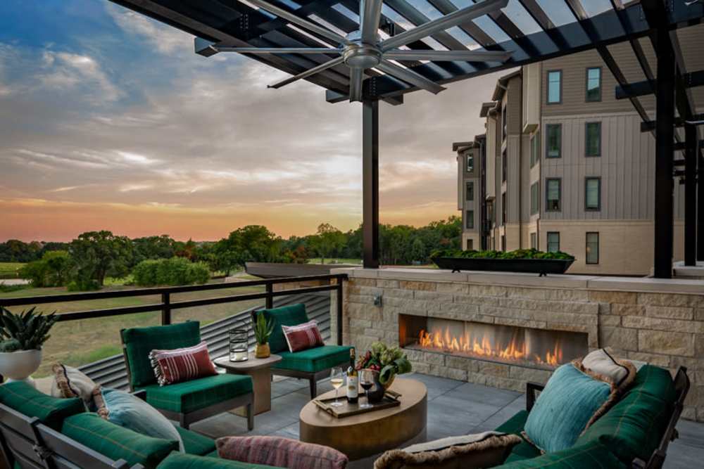Outdoor patio with fireplace at Touchmark at Emerald Lake in McKinney, Texas