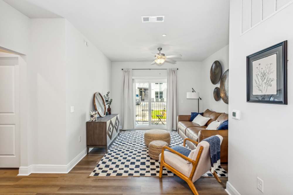 Pet-Friendly Apartments in Pensacola, FL - City North- Living Room with Ceiling Fan, Wood-Style Floors, and Fireplace
