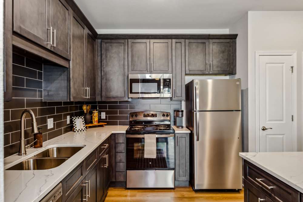 Pensacola, FL Pet-Friendly Apartments - City North - Kitchen with Stainless-Steel Appliances, Cabinets, and Granite-Style Countertops