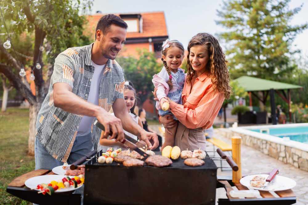 Family grilling outdoors by the pool at Retreat at RTP in Durham, North Carolina