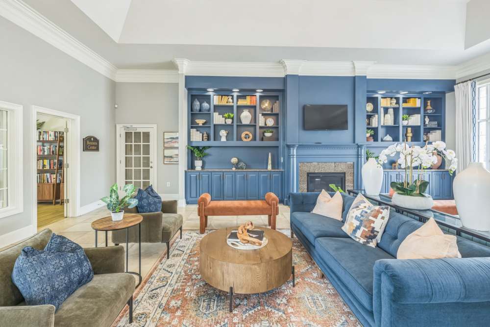 Clubhouse living area with blue sofa and carpet at Meridian Watermark in North Chesterfield, Virginia