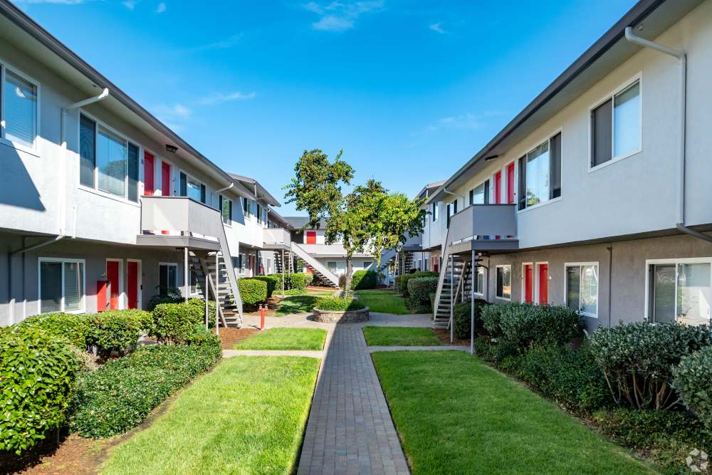 Two-Bedroom Apartments in San Leandro, CA - Marina Plaza Apartments - Courtyard with a Manicured Lawn, Apartment Complex View, and Sidewalk Access