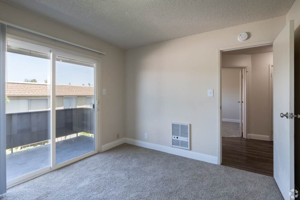 Pet-Friendly Apartments in San Leandro, CA - Marina Plaza Apartments- Living Room with Carpeted Floors, and Window