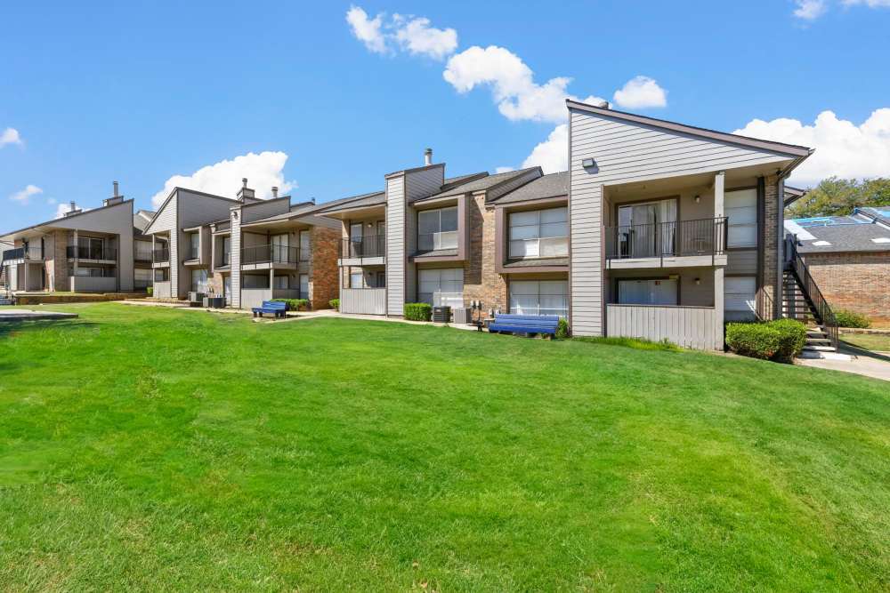 Exterior view of apartment with green lawn at Stone Canyon in Arlington, Texas 