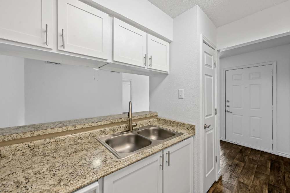 Granite countertops and a sink in the kitchen at Broadmoor Place in Irving, Texas
