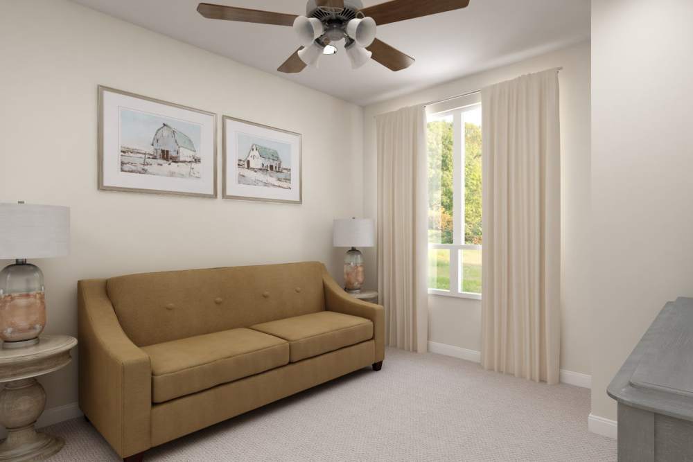 A living room with yellow couch and wall paintings at Harmony at Tucker Station in Louisville, Kentucky