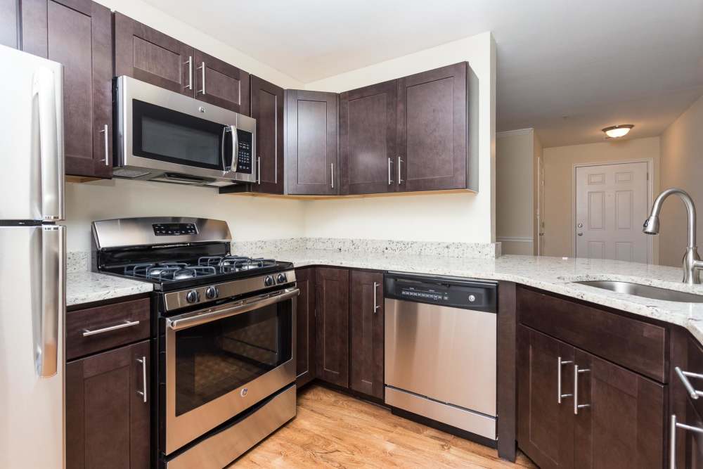 Modern kitchen with stainless-steel, granite countertops, hardwood flooring at Beacon Place at Kentlands in Gaithersburg, Maryland
