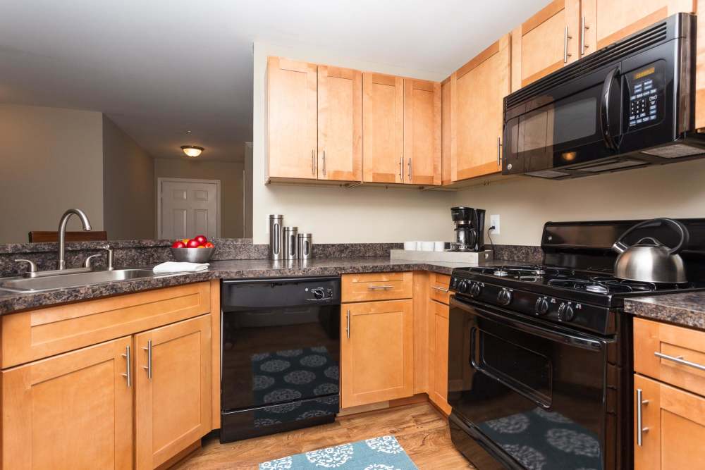 Spacious kitchen with wooden cabinets, granite countertops at Beacon Place at Kentlands in Gaithersburg, Maryland