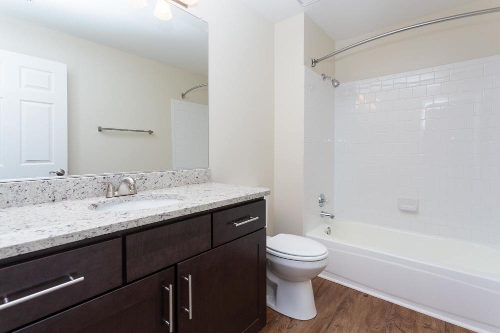 Bright bathroom with a mirror, granite counter and a wash basin at Beacon Place at Kentlands in Gaithersburg, Maryland