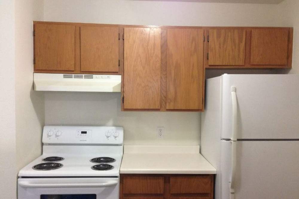 Kitchen with white appliances at Columbine Apartments in Littleton, Colorado