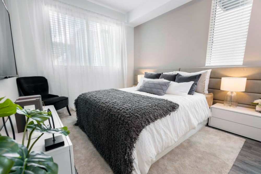 Brightly lit bedroom with hardwood-style flooring at Sophia Square in Homestead, Florida