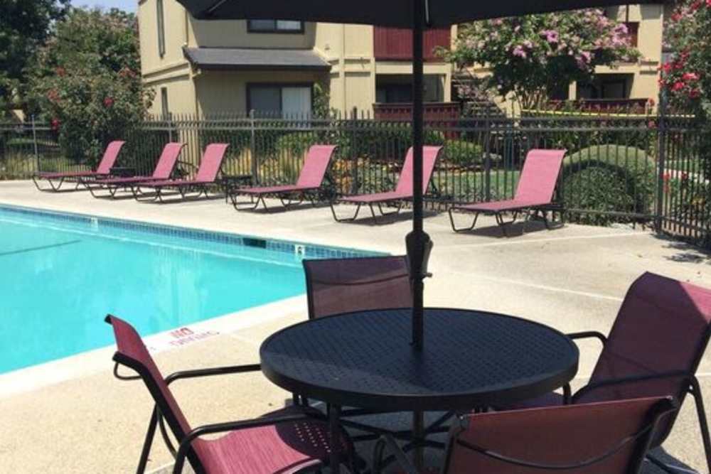 A patio with chairs by a sparkling pool at The Fairmont in Woodland, California