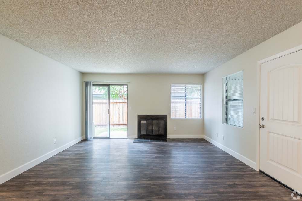 Spacious living room with wood-style flooring and a fireplace at Ashford Park in Sacramento, California