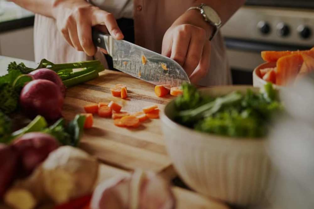 Resident cooking in their kitchen at Indigo Stuart in Stuart, Florida