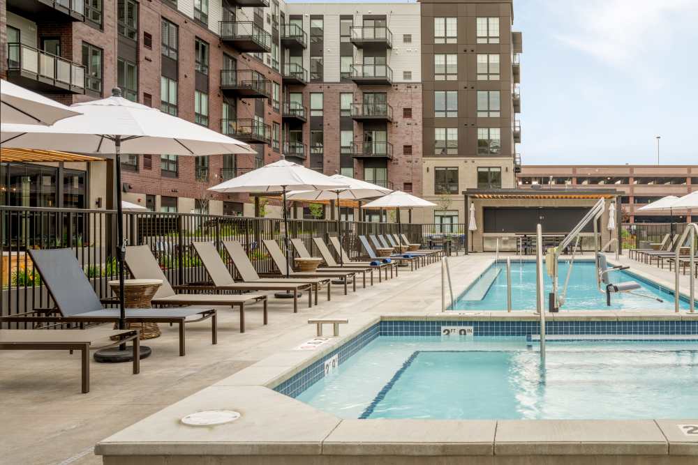 Modern Apartment Complex Featuring Outdoor Swimming Pool and Lounge Chairs at Amira Minnetonka in Minnetonka, Minnesota