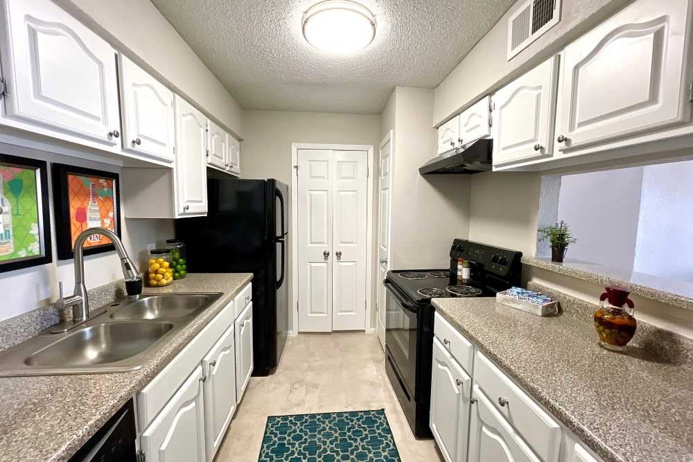 Kitchen with energy-efficient black appliances at The Abbey at Medical Center in San Antonio, Texas