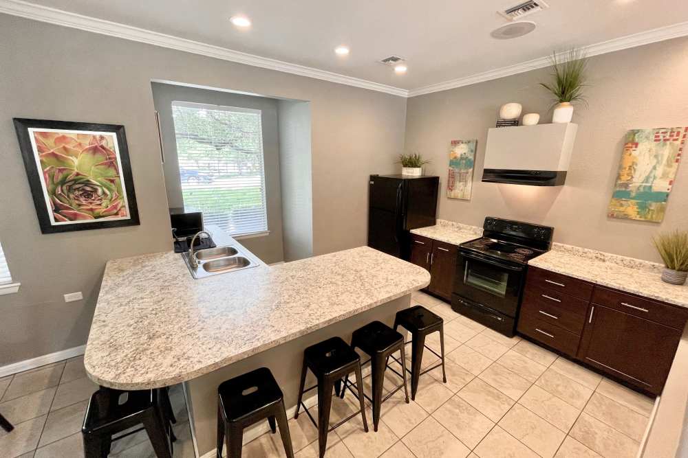 Clubhouse kitchen with bar seating at The Abbey at Medical Center in San Antonio, Texas