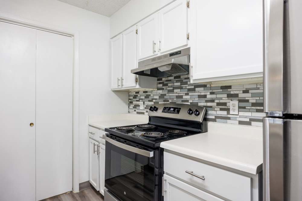 Modern kitchen featuring stainless steel appliances, granite black and white, and wooden cabinets