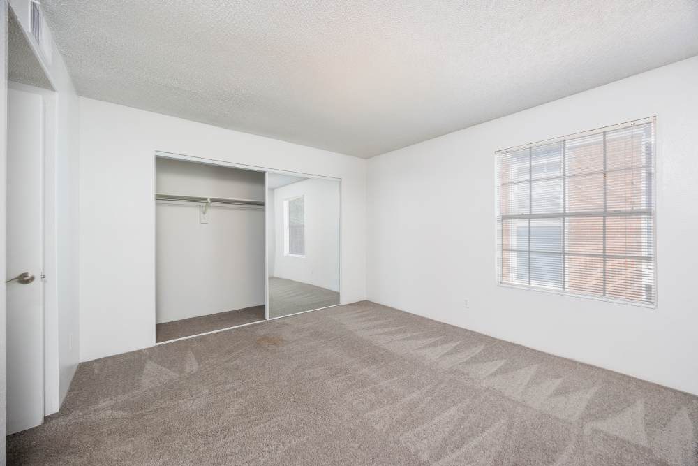 Compact workspace with a desk, chair, and laptop in a corner of the bedroom