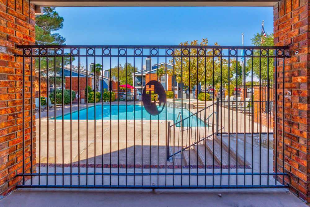 A spacious outdoor swimming pool surrounded by lounge chairs and umbrellas.