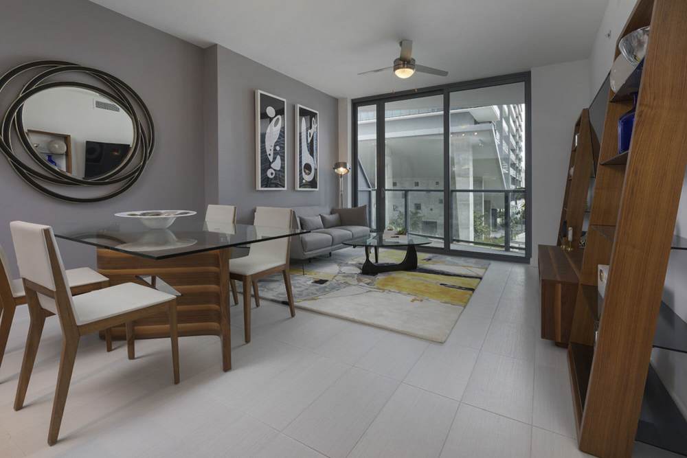 Living room with white flooring and access to private balcony at Solitair Brickell Apartments in Miami,Florida