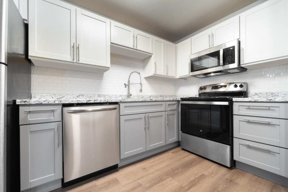 Spacious kitchen with white and wooden cabinets, microwave and stainless-steel appliances at Lantera Apartments in Seattle, Washington