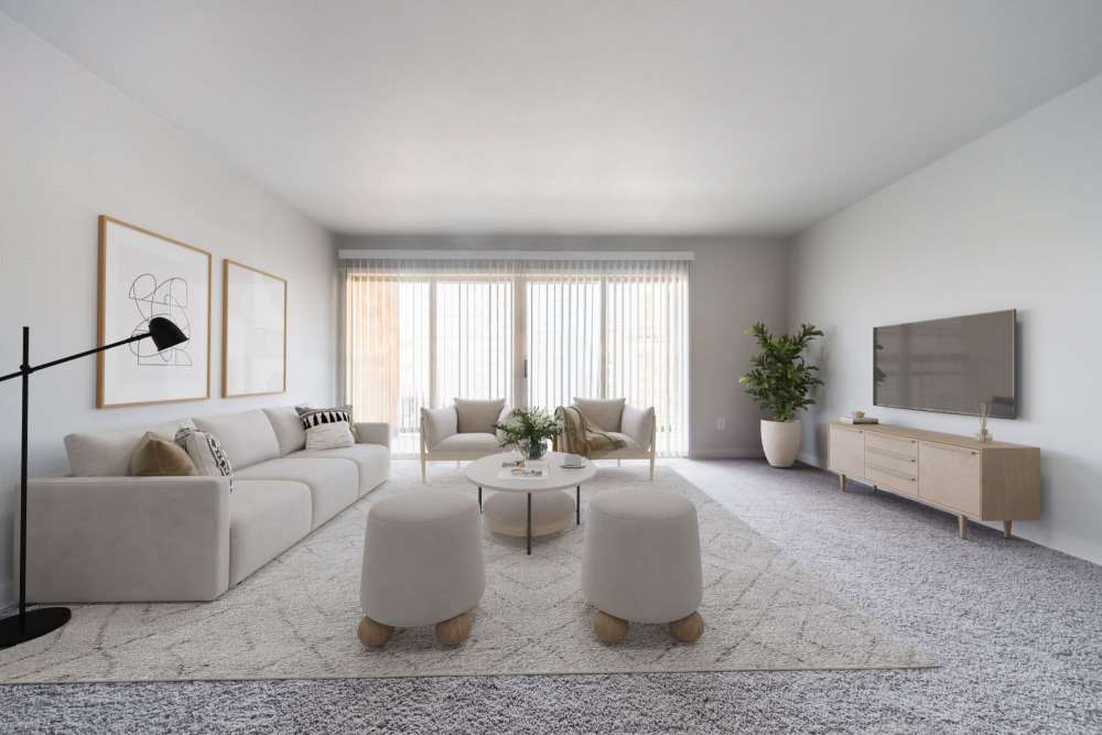 Spacious, bright living room with a white couch, two armchairs, a coffee table and a TV stand at Lantera Apartments in Seattle, Washington