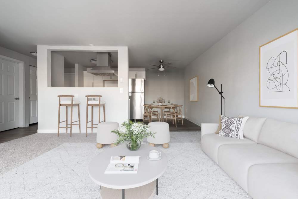 Living room with a comfortable couch, breakfast counter and an open kitchen at Lantera Apartments in Seattle, Washington