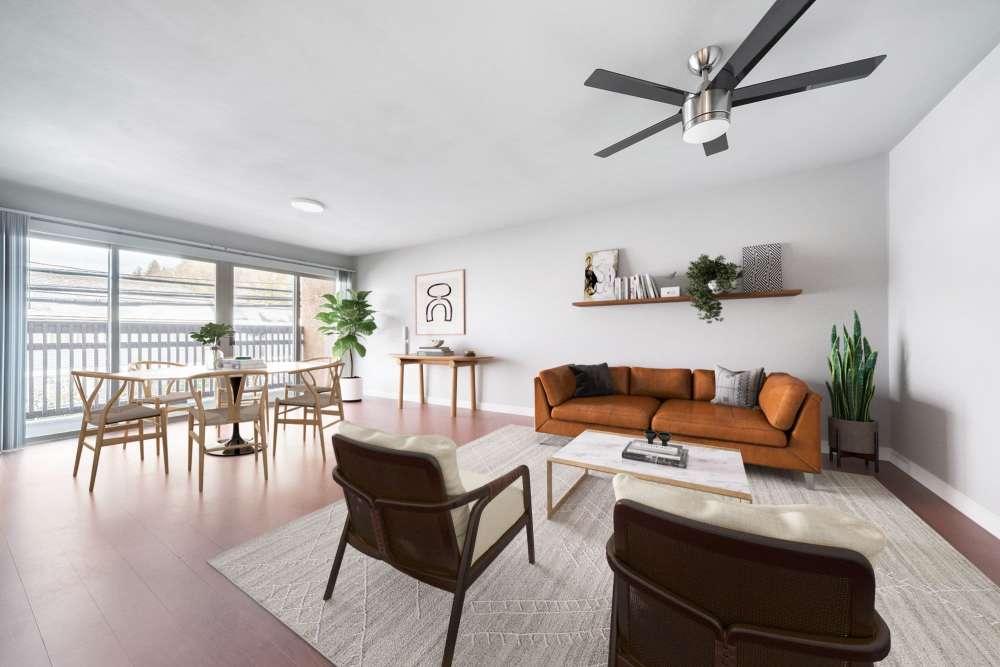 Bright living room with a couch, coffee table and a dining table with chairs at Lantera Apartments in Seattle, Washington