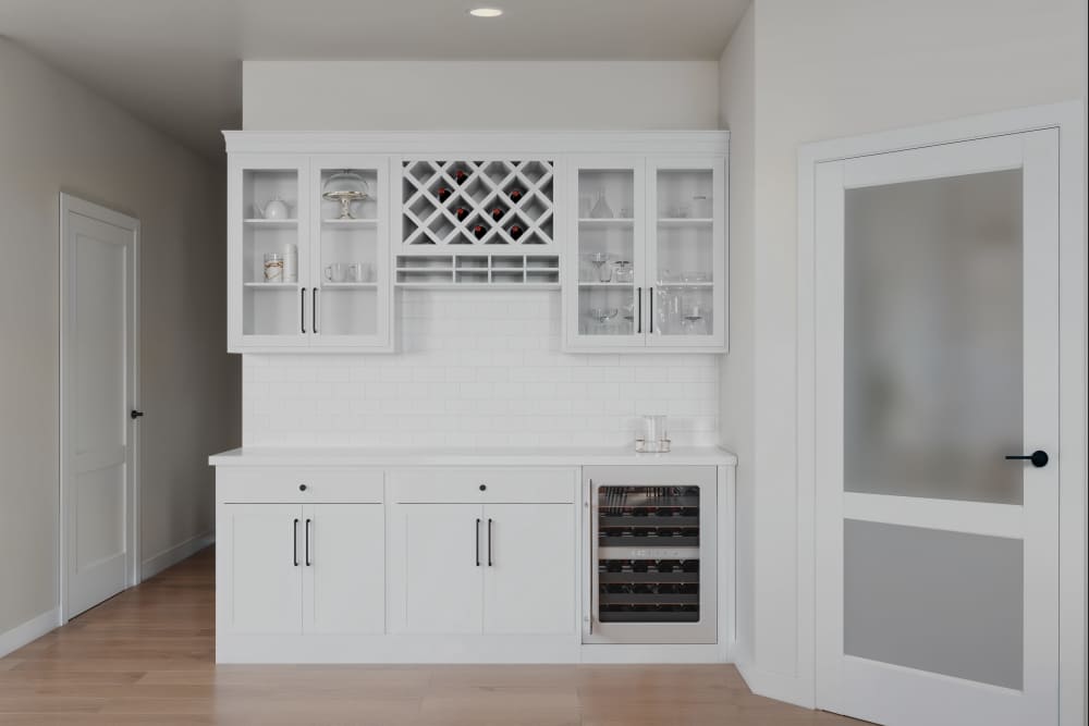 Stylish White Kitchen Bar With Wine Rack And Modern Wine Cooler. at Amira Minnetonka in Minnetonka, Minnesota