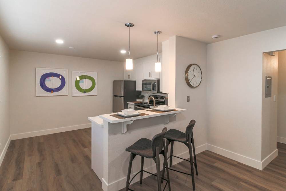 A modern kitchen featuring bar stools and a sleek refrigerator, creating a cozy dining space at Davis, California