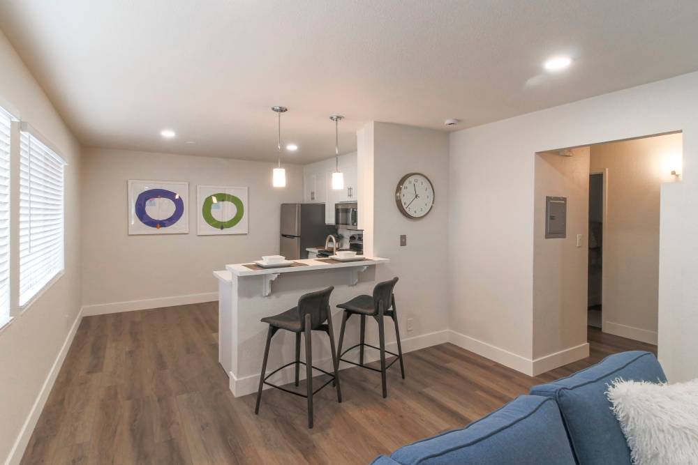 A modern kitchen featuring bar stools and a sleek refrigerator, creating a cozy dining space at  Davis, California