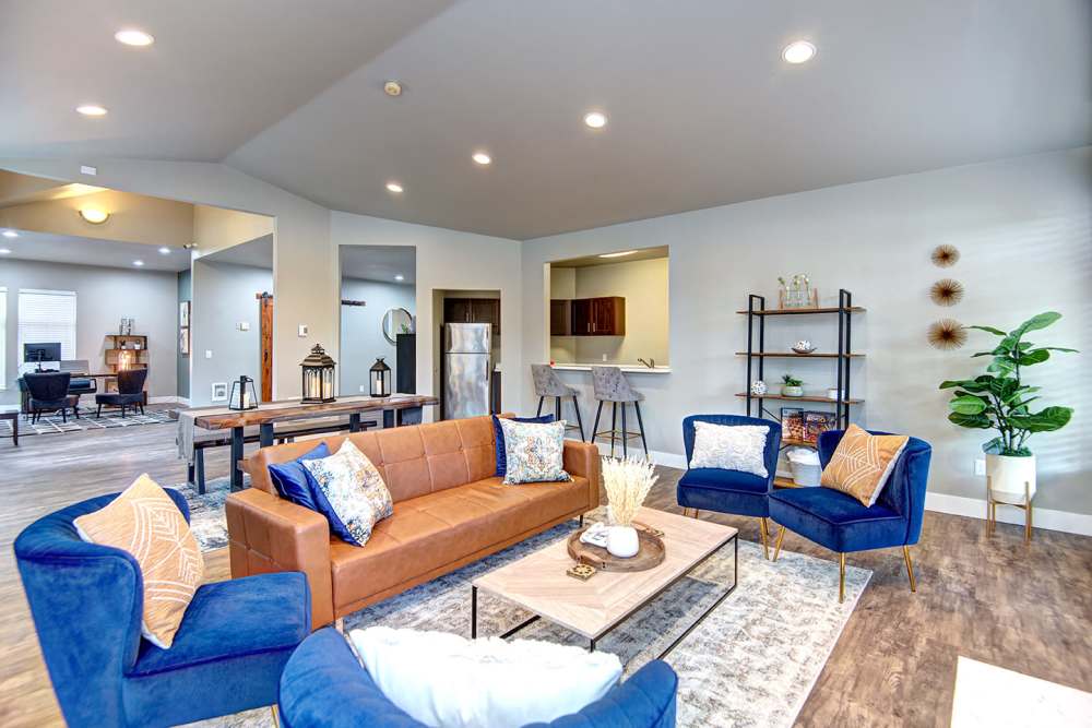 Resident seating area with large chairs, coffee tables and wood-style flooring at Briarstone in Tacoma, Washington